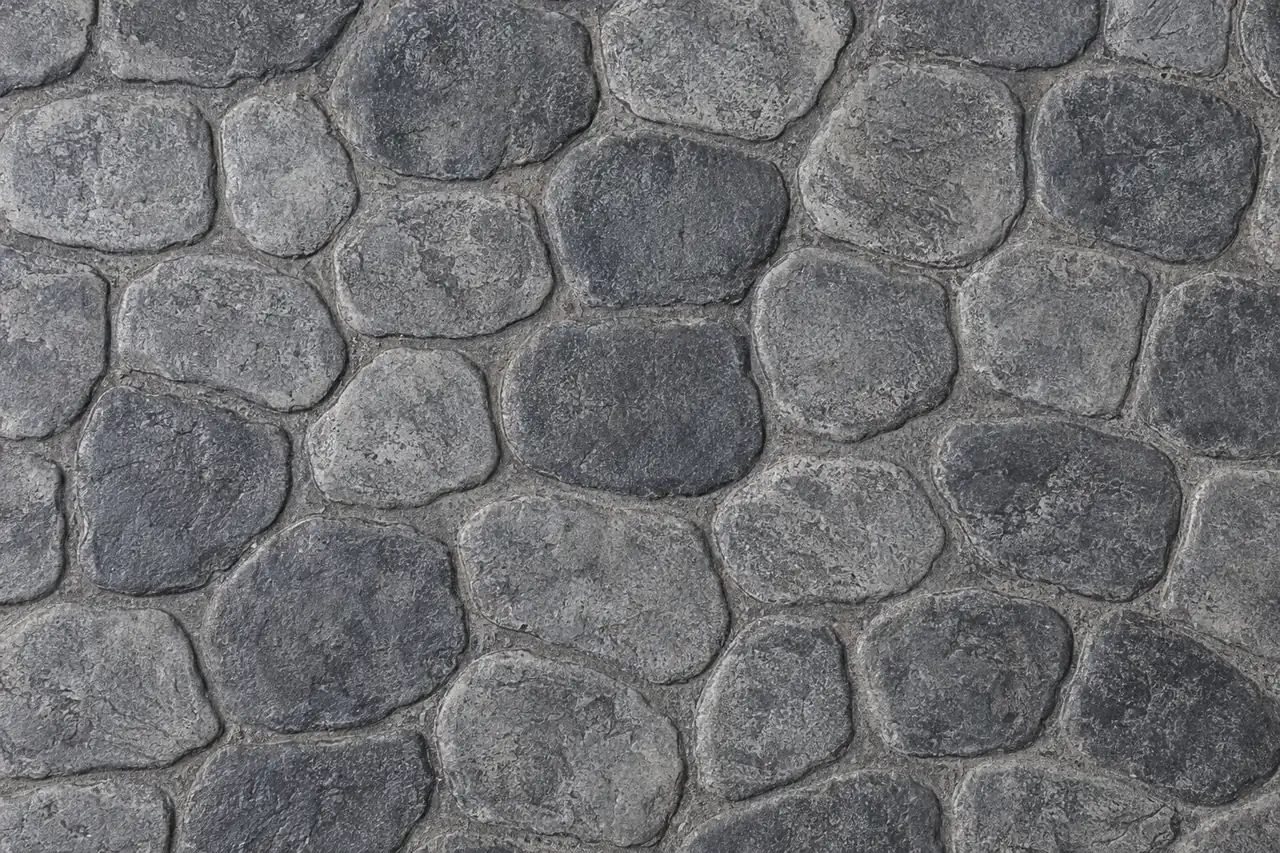 Top-down view of cobblestone stamped concrete in gray and charcoal tones