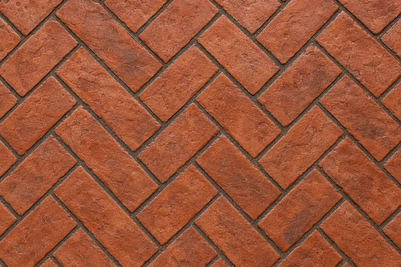 Top-down view of brick herringbone stamped concrete in terra-cotta red