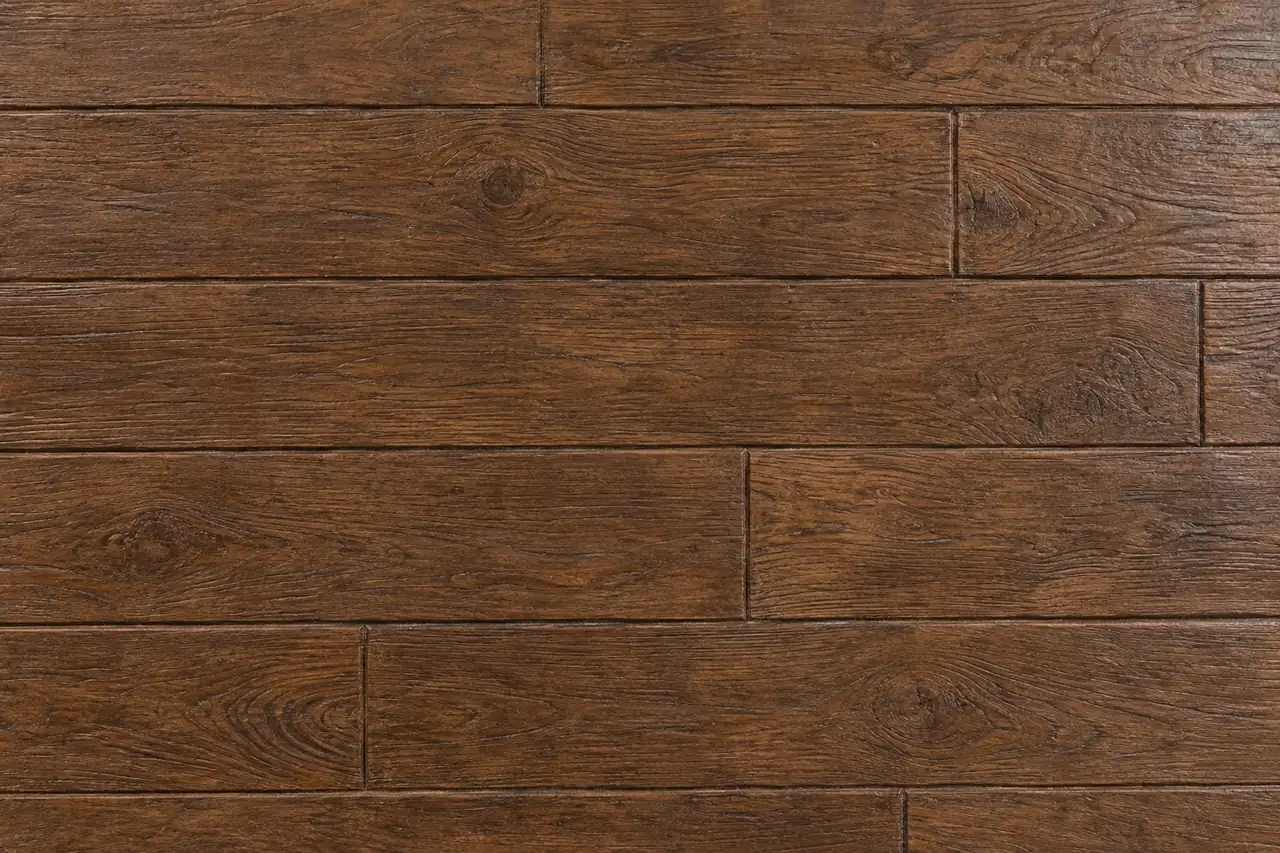 Top-down view of wood plank stamped concrete in warm walnut brown with grain texture