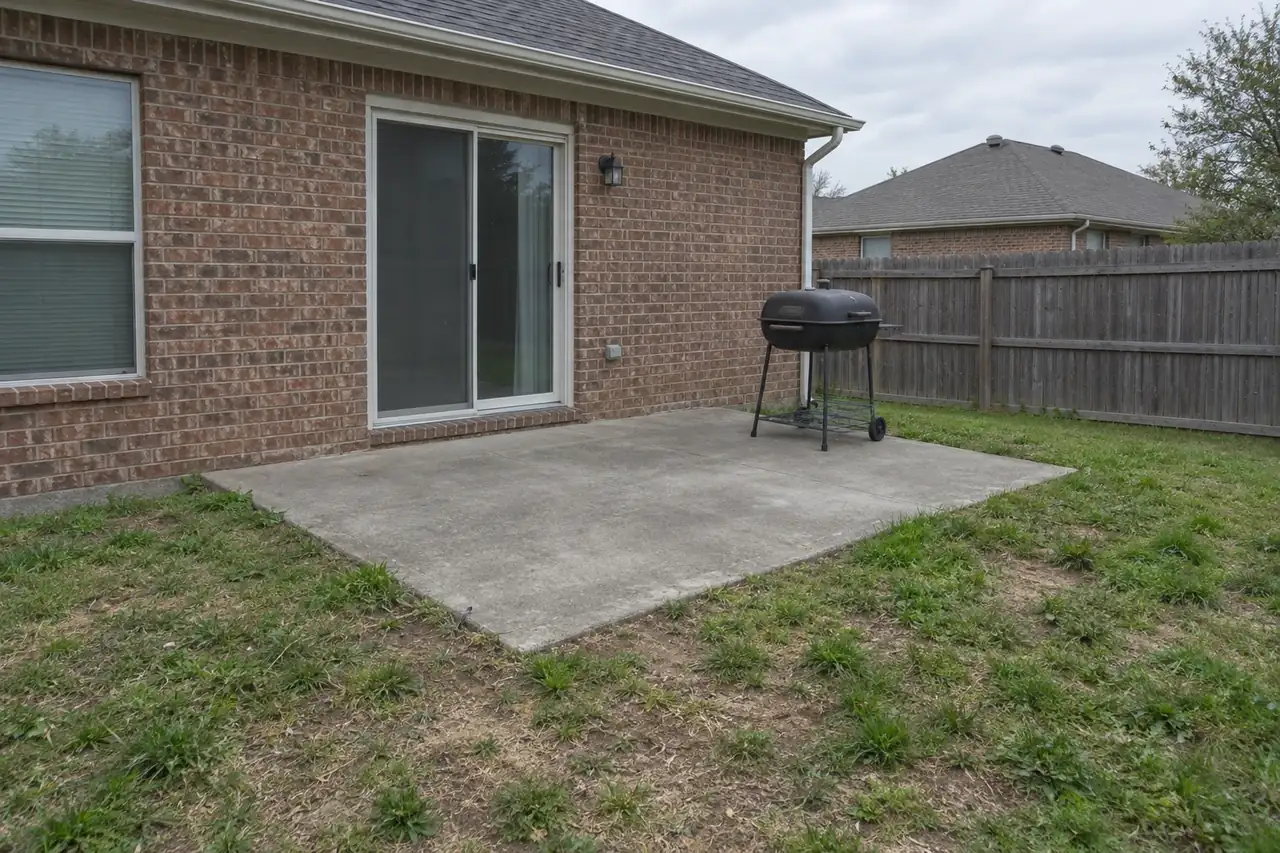 Concept image: a plain gray slab and a stamped patio with a fire pit - before